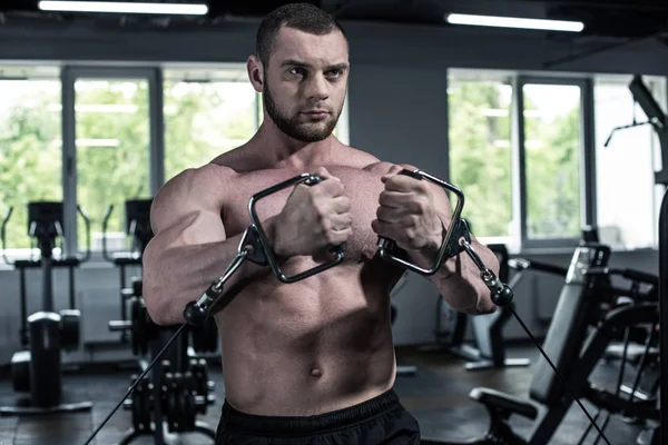 Shirtless bodybuilder opleiding met gewicht machine — Stockfoto