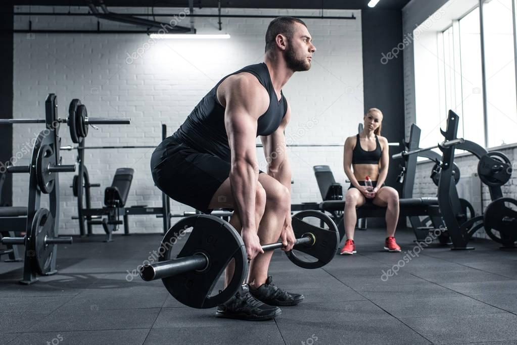 man doing strength training while woman sitting
