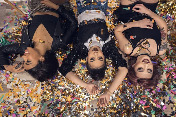 Mnohonárodnostní dívky leží na podlaze s konfety — Stock fotografie