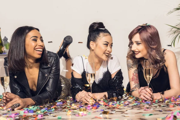 Girls lying on floor with glasses of champagne — Stock Photo, Image