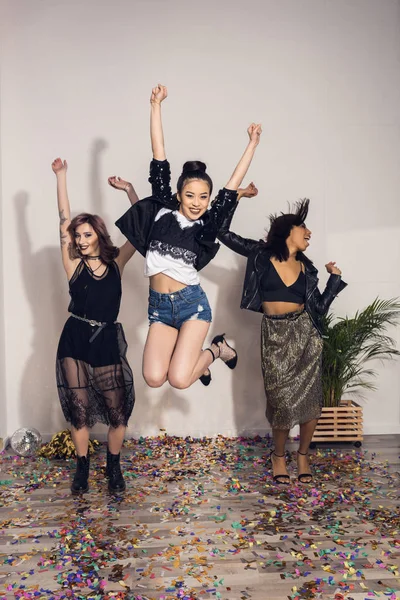 Cheerful multiethnic girls jumping at party — Stock Photo, Image