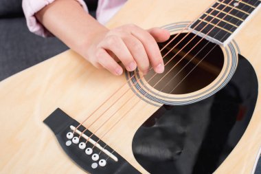 girl practicing to play on guitar  clipart
