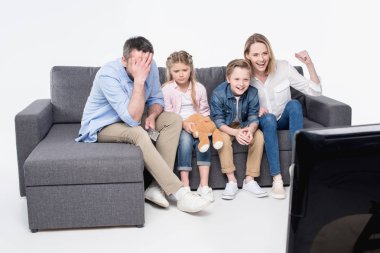 family sitting on sofa and watching tv clipart