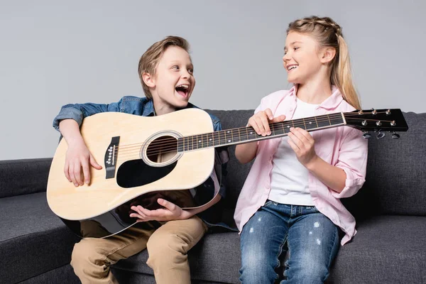 Geschwister spielen gemeinsam auf der Gitarre — Stockfoto