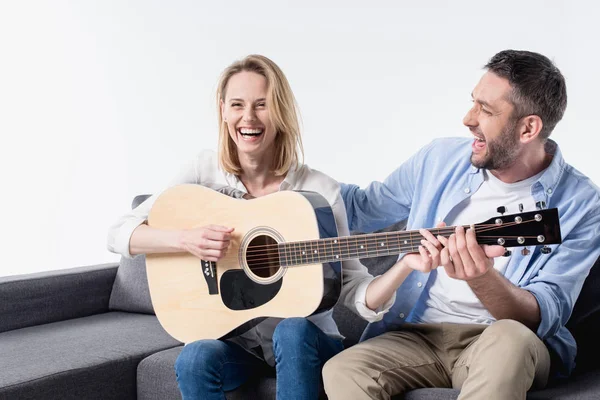 Мужчина учит женщину играть на гитаре — стоковое фото