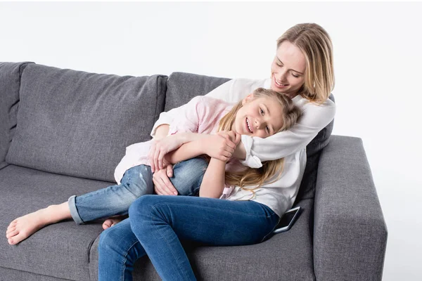 Mor med lilla dotter sitter på soffa — Stockfoto