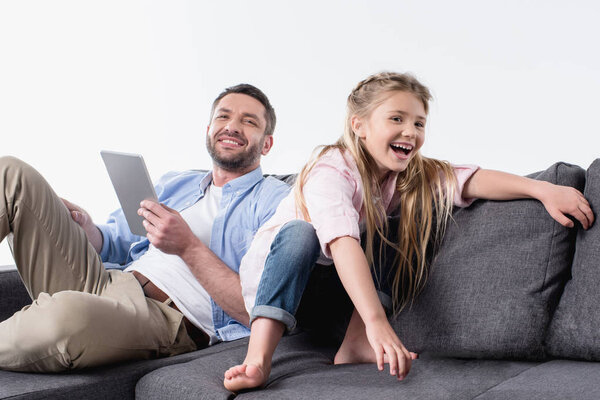 father with daughter sitting on sofa