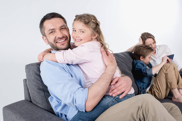 father with daughter embracing and looking at camera