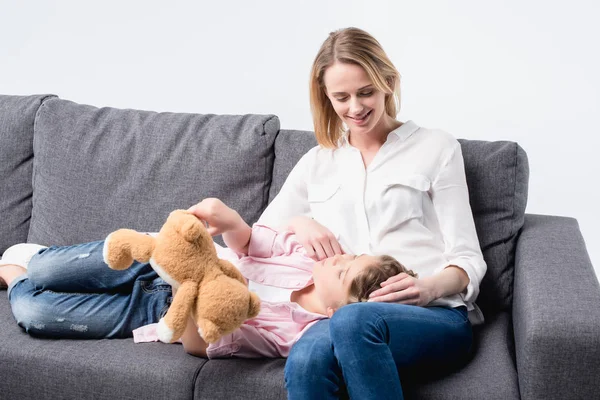 Mor med lilla dotter sitter på soffa — Stockfoto