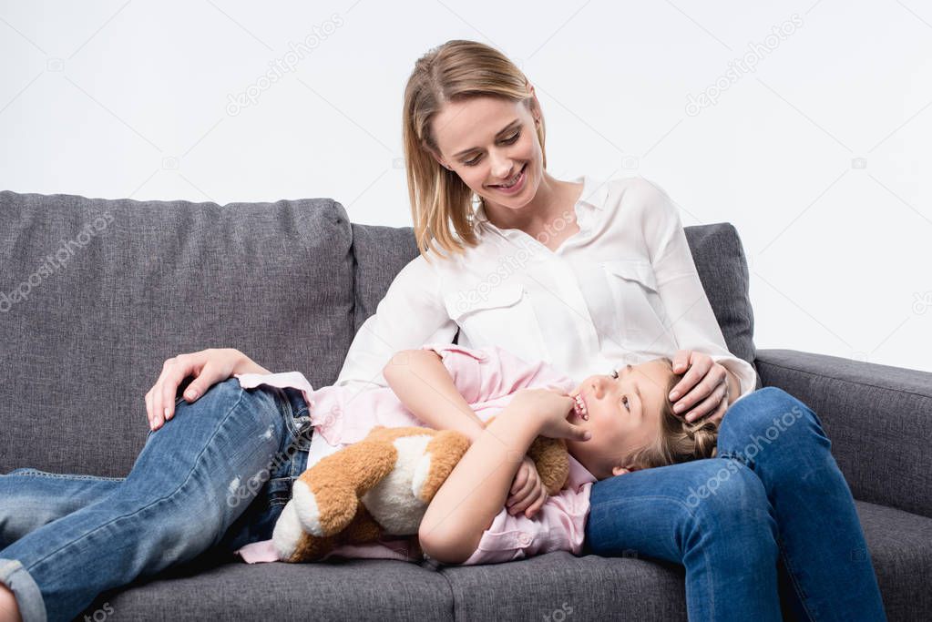 1 mother with little daughter sitting on sofa