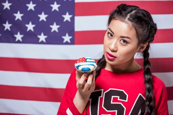 Kvinna med cupcake dekorerad med amerikanska flaggan — Stockfoto