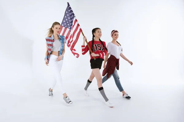 Meninas multiétnicas andando com bandeira americana — Fotografia de Stock