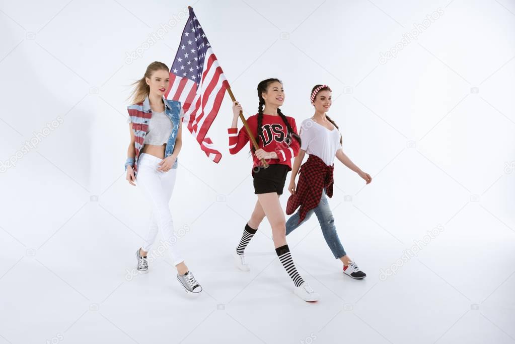 multiethnic girls walking with american flag