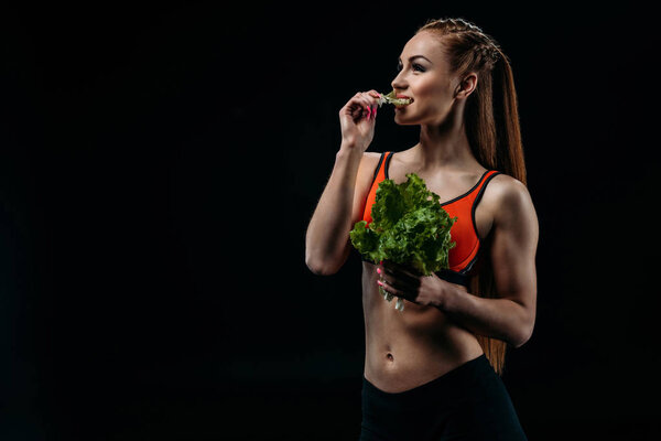 sportswoman eating salad leaves