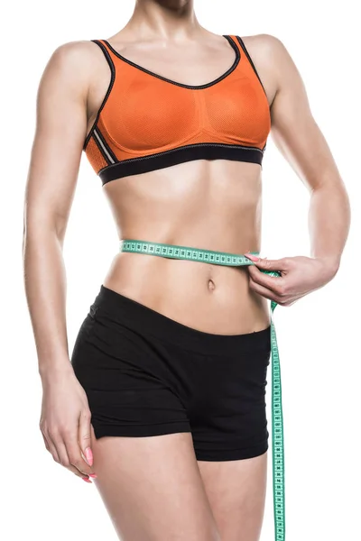 Sportswoman measuring her waistline — Stock Photo, Image