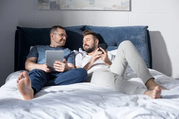 Couple homosexuel utilisant des appareils numériques — Photo