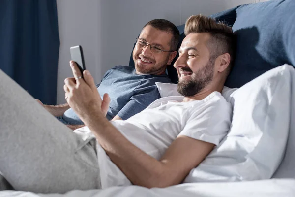 Homosexual couple using smartphone — Stock Photo, Image