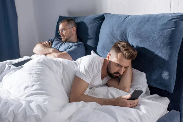 Homosexuální pár pomocí digitálních zařízení — Stock fotografie