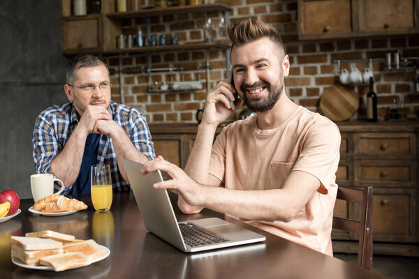 Человек с ноутбуком во время завтрака
