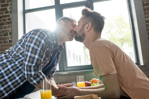 Pareja homosexual besándose durante el desayuno —  Fotos de Stock