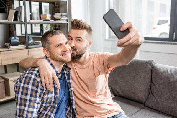 homosexual couple taking selfie on smartphone