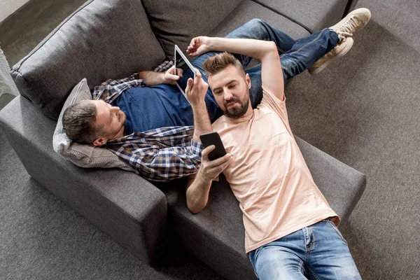 Casal homossexual usando dispositivos digitais — Fotografia de Stock