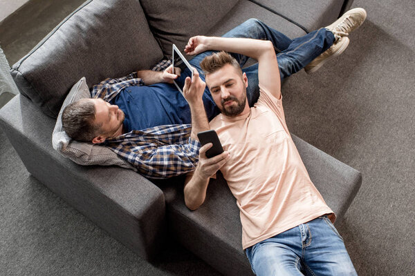 homosexual couple using digital devices