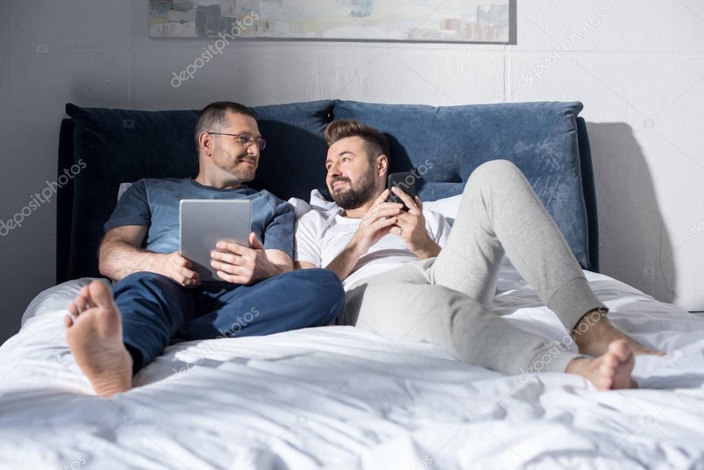 Homosexual couple using digital devices 