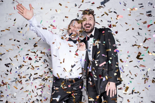 Happy homosexual couple celebrating with confetti — Stock Photo, Image