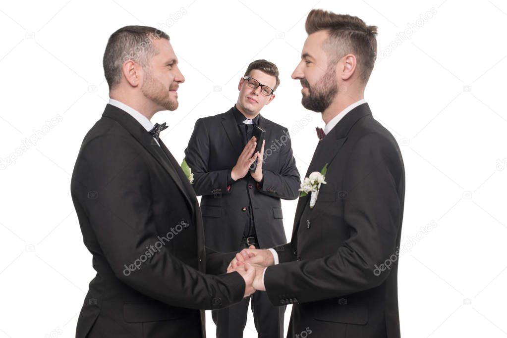 homosexual couple holding hands at wedding