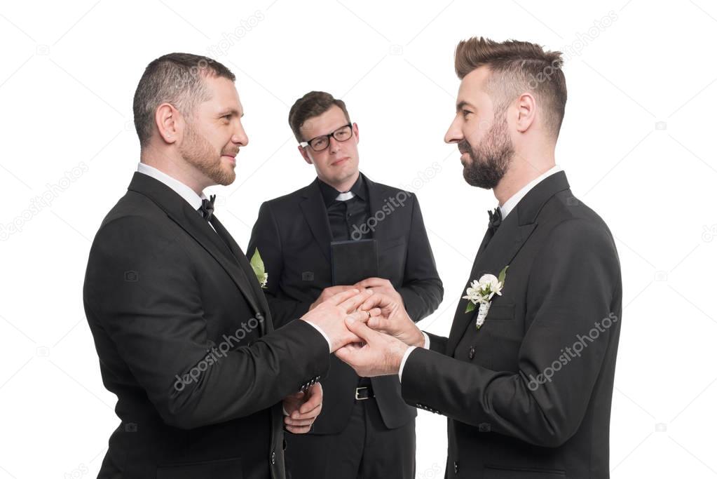 homosexual couple exchanging rings at wedding