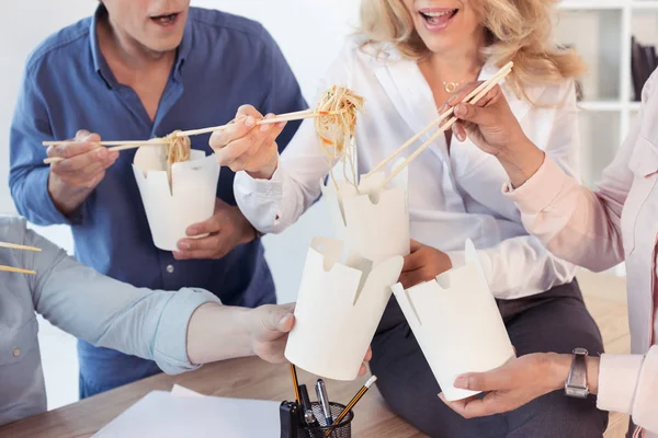 Coworkers eating asian food — Stock Photo, Image