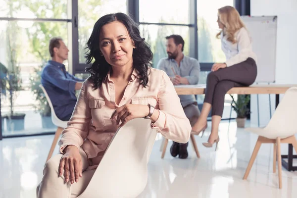 Mature asian businesswoman sitting at office — Stock Photo, Image