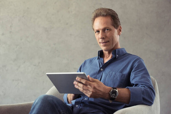 mature man using digital tablet