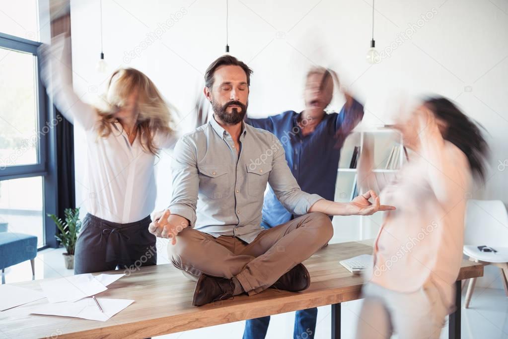 Businessman meditating in office 