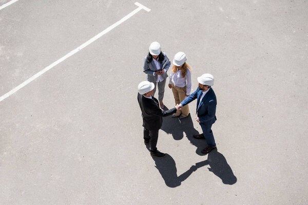 Architects in formal wear talking at meeting
