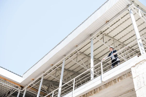 Arquitecto en traje de pie en el sitio de construcción — Foto de Stock