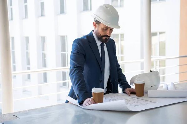 Middle aged architect looking at blueprints — Stock Photo, Image
