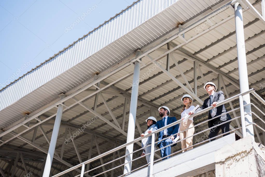 architects in formal wear standing at construction