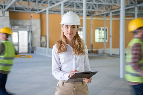 Mature contractor making notes at clipboard — Stock Photo, Image