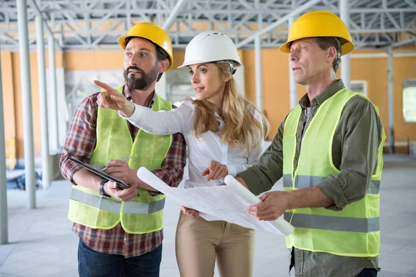 Constructores y contratista hablando en el sitio de construcción — Foto de Stock