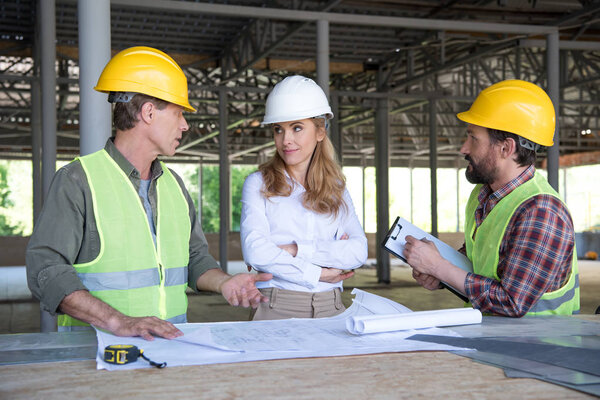 builders and contractor talking on construction site
