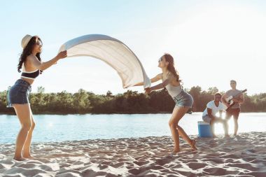 riverside üzerinde plaj battaniye sallayarak kızlar