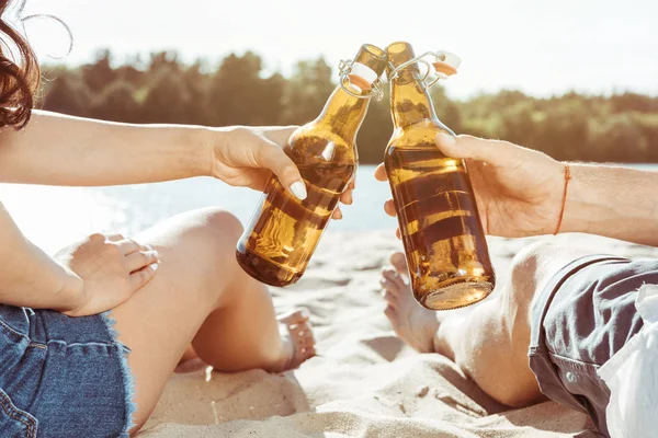 Couple clinking bottles — Stock Photo, Image