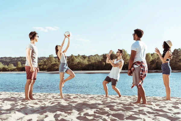 Amigos jugando voleibol en la playa de arena —  Fotos de Stock