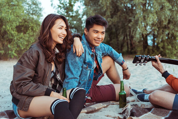 smiling couple sitting on sandy beach