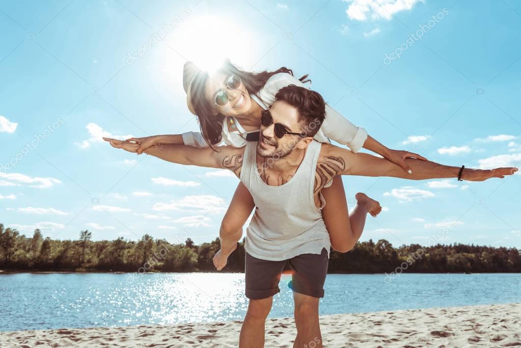 couple piggybacking on beach