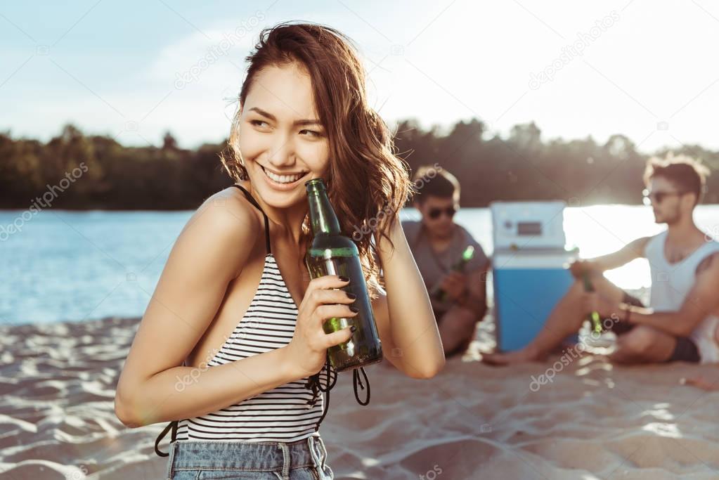 woman drinking beer on sandy beach