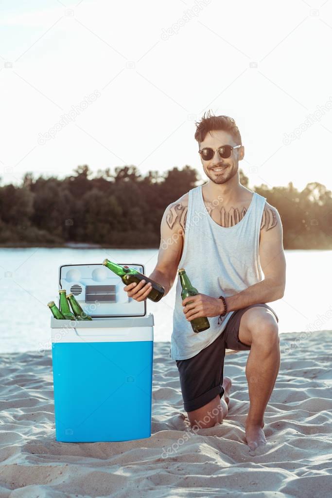 man taking beer from portable fridge