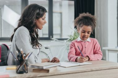 mother helping daughter with homework clipart